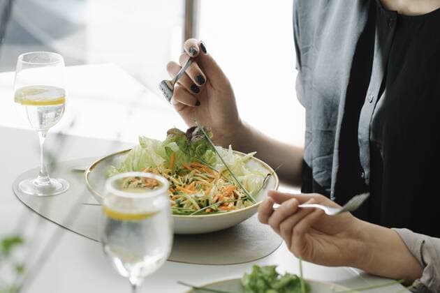 Close-up of two women eating salad in a restaurant model released Symbolfoto  AHSF00360