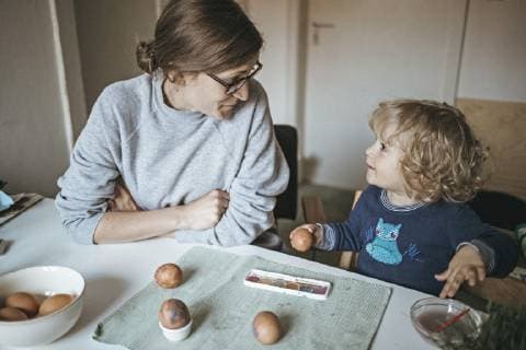 Mother and daughter sitting at table at home painting Easter eggs model released Symbolfoto  DWF00432