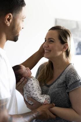 Happy parents holding newborn baby at home model released Symbolfoto property released  ERRF01353