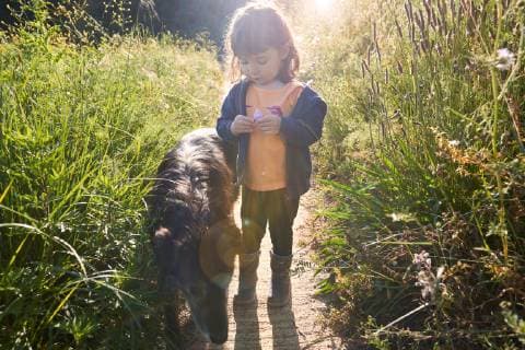 IMAGO Creative, Ostern, Bräuche, Osterspaziergang Toddler girl walking with dog in nature model released Symbolfoto property released  GEMF02969