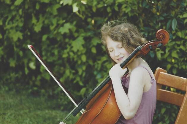 A girl playing the cello with eyes closed model released Symbolfoto  IHF00021