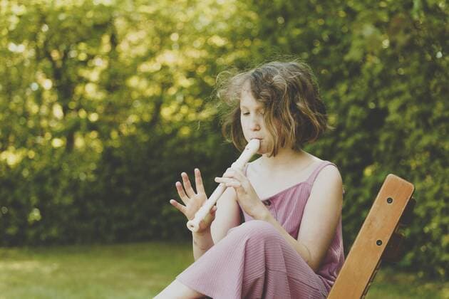 A girl playing the flute in the garden model released Symbolfoto  IHF00035