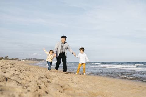 IMAGO Creative, Ostern, Bräuche, Osterspaziergang Grandfather having fun with his grandchildren on the beach model released Symbolfoto  JRFF03205