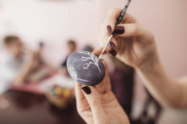 Woman painting Easter egg at home with children in background model released Symbolfoto property released  KMKF00928
