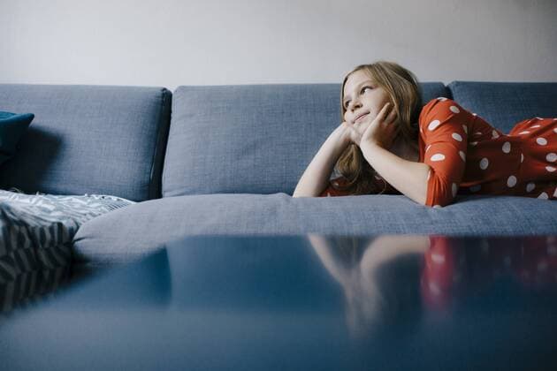 Girl lying on couch at home model released Symbolfoto property released  KNSF05880