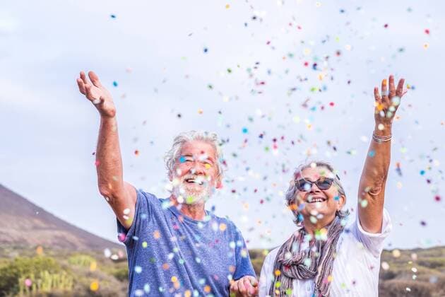 Happy senior couple celebrating with confetti outdoors model released Symbolfoto  SIPF01979