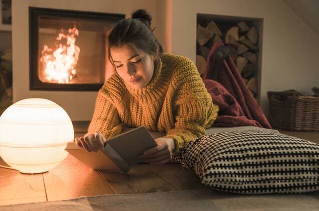 Young woman reading book at the fireplace at home model released Symbolfoto property released  UUF17280