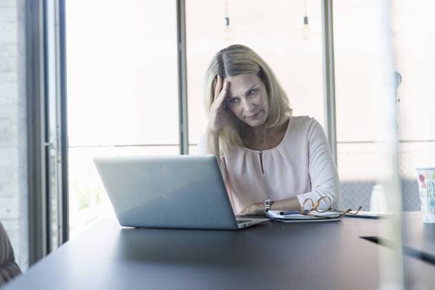 Stressed businesswoman using laptop in office model released Symbolfoto property released  UUF17495