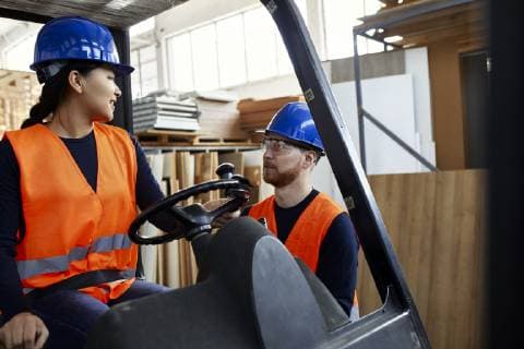 Man talking to female worker on forklift in factory model released Symbolfoto property released  ZEDF02155