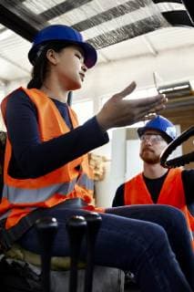 Man talking to female worker on forklift in factory model released Symbolfoto property released  ZEDF02156