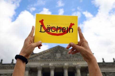 Fridays for Future - GER, Germany, Deutschland, Berlin, 28.06.2019 - Berlin-Mitte: Schüler, Studenten und Klimaaktivisten demonstrieren mit einer Menschenkette vor dem Reichstag im Regierungsviertel für das Klima, den Klimaschutz und eine bessere und saubere Umwelt. Die Schüler fordern mit ihren allwöchentlichen Protesten den sofortigen Kohleausstieg und eine Klimawende. Die Fridays for Future Bewegung wurde von Greta Thunberg in Schweden ins Leben gerufen. - Demoschild mit der Aufschrift: Lächeln *** Fridays for Future GER, Germany, Deutschland, Berlin, 28 06 2019 Berlin Mitte Pupils, students and climate activists demonstrate with a human chain in front of the Reichstag in the government district for climate, climate protection and a better and cleaner environment With their weekly protests the pupils demand the immediate withdraw