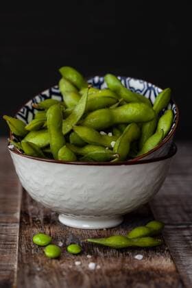 Kleine Schüssel mit frischen grünen Edamame mit grobem Salz - Green soy beans with salt Kleine Schüssel mit frischen grünen Edamame mit grobem Salz - Green soy beans with salt