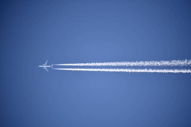 Flugzeug mit Kondensstreifen am Himmel