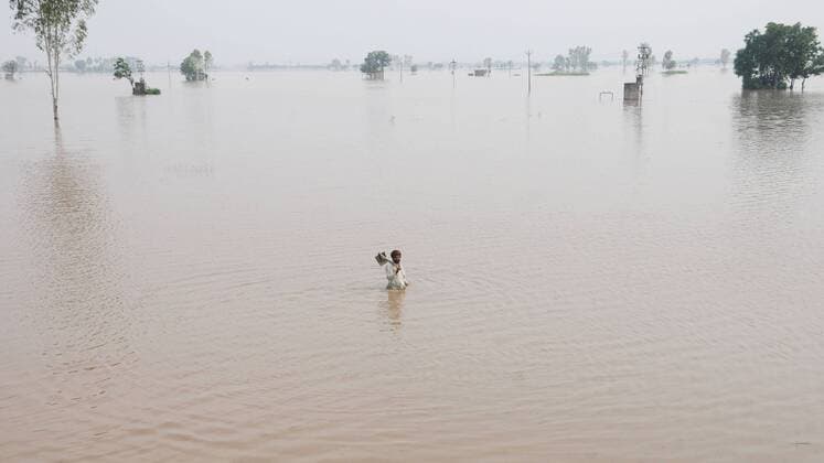 News Bilder des Tages SANGRUR, INDIA - JULY 19: A man wades through a breach in the Ghaggar River which widened in Pulad village, on July 19, 2019 in Sangrur, India. The Ghaggar river on Thursday crossed the danger mark in Sangrur district and caused a 70-foot-long breach on its banks at Phulad village of Moonak sub-division, forcing the administration to call in the army and the National Disaster Response Force (NDRF) to plug it. The breach, caused by rising level of water in Ghaggar due to heavy rain, developed at 6am and went up to 70 feet by the evening as the teams of the army, NDRF and the State Disaster Response Force (SDRF) failed to plug it. (Photo by Bharat Bhushan Hindustan Times ) Ghaggar River Breaches Banks In Sangrur; Army, NDRF Called In To Plug Gap