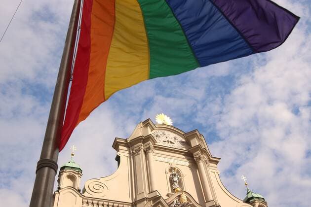 Symbolbild zum Thema Homosexualität und Kirche: Regenbogenflagge weht vor der Peterskirche anlässlich des CSD Christopher Street Day s in der Innenstadt München, Bayern, Deutschland *** Symbol image on homosexuality and church Rainbow flag waving in front of St. Peters Church on CSD Christopher Street Day s in downtown Munich, Bavaria, Germany