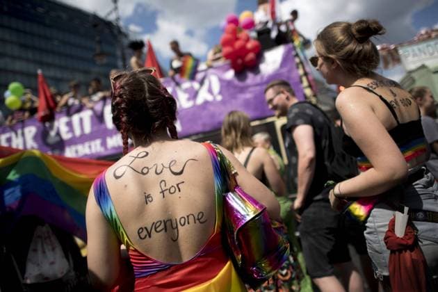 Christopher Street Day Berlin DEU, Deutschland, Germany, Berlin, 27.07.2019 Teilnehmerin mit Schriftzug Love Is For Everyone vor dem Wagen der Gewerkschaft DGB und Verdi mit Schild Mehr Zeit fuer Sex Weniger Arbeit mehr Leben auf der schwul-lesbischen Gedenkparade Christopher Street Day CSD Pride unter dem Motto 50 Jahre Stonewall Every Riots Starts With your Voice in Berlin. Participants with sign Love Is For Everyone at the Berlin s annual Christopher Street Day CSD Pride parade in Berlin. Gays and lesbians all around the world are celebrating the Christopher Street Day gay and lesbian pride parade under the slogan 50 years Stonewall Every Riots Starts With your Voice. Berlin, known as a tolerant and open city, has a very active gay community. This year an equal marriage of gays and lesbians and a fight against Homophobia are the focus