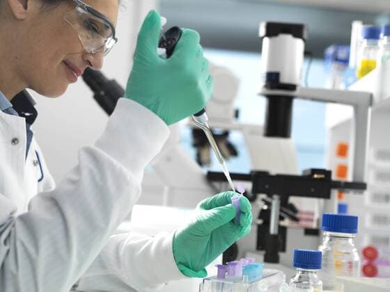 Biotech Research, Scientist pipetting sample into a vial ready for analysis during a experiment in the laboratory model released Symbolfoto property released  ABRF00403