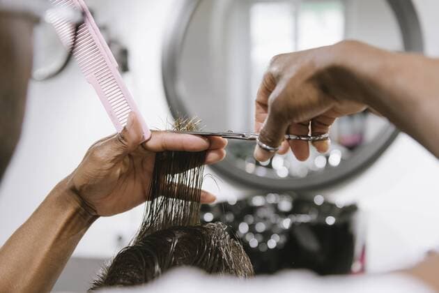 Close-up of barber cutting hair of a customer in barber shop model released Symbolfoto property released  AHSF00509