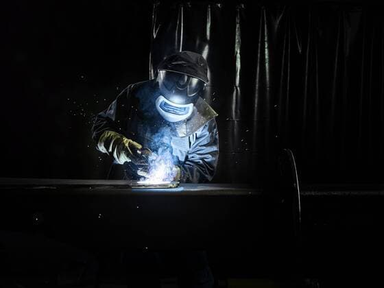 Industrial worker in protective clothing welding metal with welding torch model released Symbolfoto property released  CVF01234