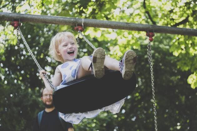 Portrait of happy ltiitle girl on a swing model released Symbolfoto  IHF00141