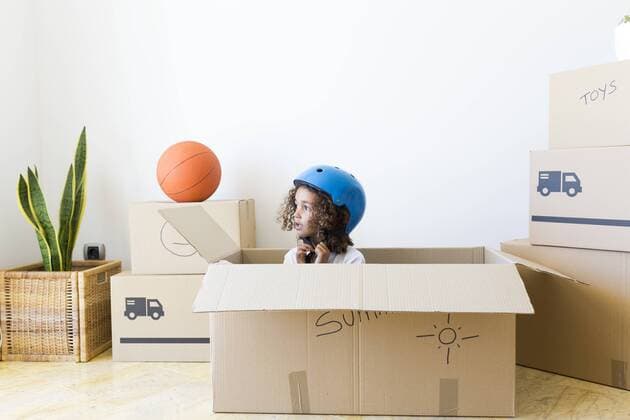 IMAGO Creative: Lokalhelden - Jugendsportbildung Girl inside cardboard box at new home closing bicycle helmet model released Symbolfoto property released  JPTF00183