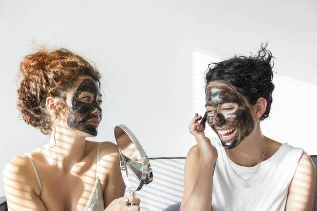 Two happy young women applying facial masks at home model released Symbolfoto property released  JPTF00242