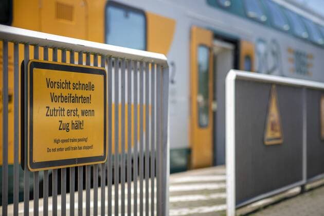 An einer Absperrung haengt ein Schild mit der Aufschrift Vorsicht schnelle Vorbeifahrten. Zutritt erst, wenn Zug haelt . Neustadt (Dosse), 26.07.2019. Neustadt (Dosse) Deutschland