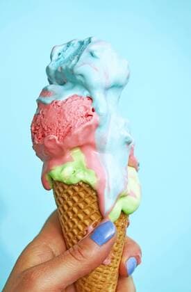 Woman s hand holding ice-cream cone with melting icecream in front of blue background model released Symbolfoto  JTF01251