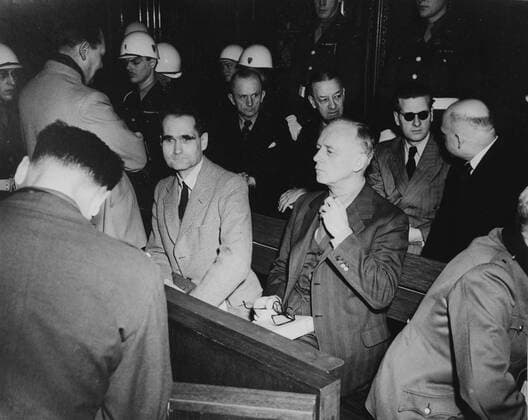 Rudolf Hess Rudolf Hess (1894â€“1987) prominent figure in Nazi Germany, acting as Adolf Hitler s deputy in the Nazi Party from 1926-41. Hess (centre in pale jacket) at the War Crimes Trials in Nuremberg, 1946. Copyright: xPhoto12 AnnxRonanxPicturexLibraryx ARP09A00423