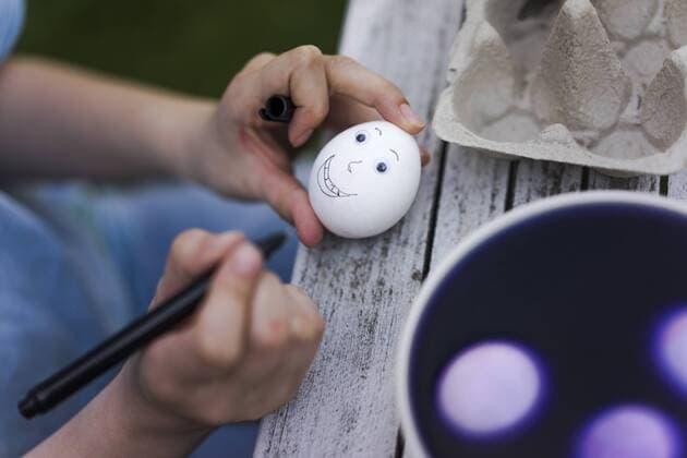 Close-up of girl painting face on Easter egg on garden table model released Symbolfoto property released  MOEF02291