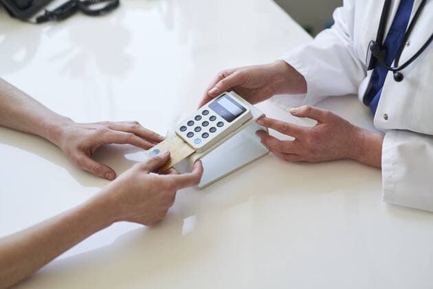 Doctor and patient with card and card reader at medical practice model released Symbolfoto  PNEF01517