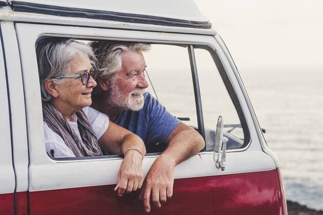 Senior couple traveling in a vintage van, looking at the sea model released Symbolfoto  SIPF02004