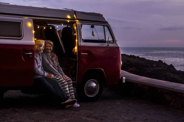 Senior couple traveling in a vintage van, watching sunset at the sea model released Symbolfoto  SIPF02030