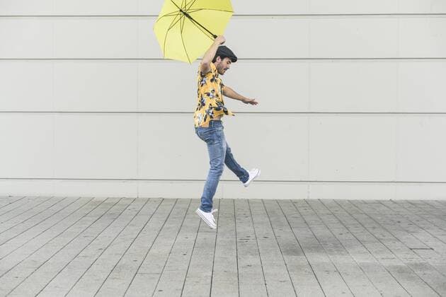 Young man with aloha shirt, dancing with yellow umbrella model released Symbolfoto  UUF17881