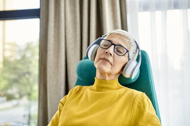 IMAGO Creative: Internationaler Frauenmonat, Gesundheit, Frauen in der Menopause Senior woman sleeping in armchair with headphones on model released Symbolfoto property released  ZEDF02410