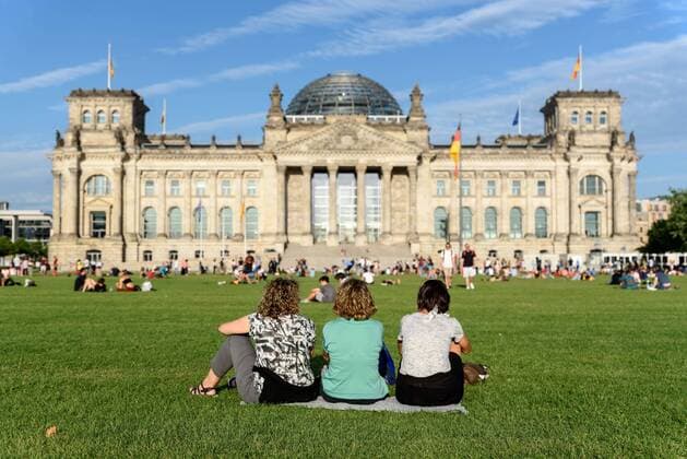 Drei Touristinnen auf der erst kürzlich wieder freigegeben Reichstagswiese vor dem Berliner Reichstag snapshot-photography F.Boillot