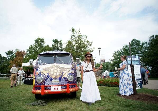 A woman dressed in 60 s clothing stands next to a Volkswagen bus on the grounds at the 50th anniversary of the Woodstock Music Festival at Bethel Woods Center For The Arts on Friday, August 16, 2019 in Bethel, New York. Woodstock was a music festival held August 15Ð18, 1969, which attracted an audience of more than 400,000 and is widely regarded as a pivotal moment in popular music history.  NYP20190816130 JOHNxANGELILLO