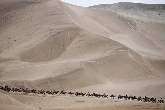 China, Karawanen unweit der Oasenstadt Dunhuang DUNHUANG, CHINA - AUGUST 20: Tourists ride camels at Mingsha Mountain and Crescent Lake scenic area August 20, 2019 in Dunhuang, Gansu Province of China.  Copyright: xVCGx CFP111235485673