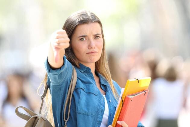  Angry student gesturing thumbs down ,model released, Symbolfoto  Copyright: xAntonioGuillemx Panthermedia26547629