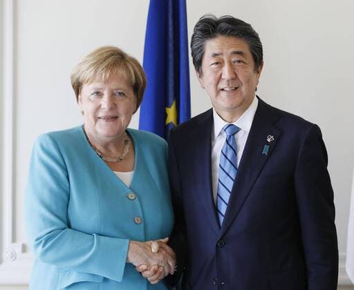 Japan-Germany talks Japanese Prime Minister Shinzo Abe and German Chancellor Angela Merkel shake hands in Biarritz, southwestern France, on Aug. 24, 2019, during their meeting on the sidelines of a Group of Seven summit starting there the following day. (Pool photo) 
