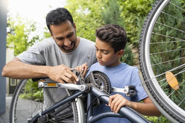 Father and son repairing bicycle together model released Symbolfoto property released  DIGF07757