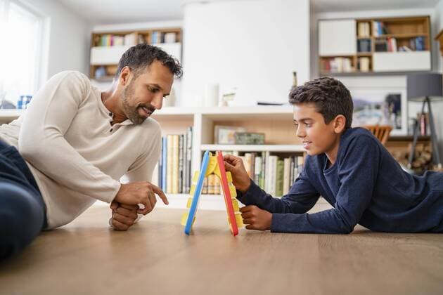 Father and son lying on the floor at home playing a game model released Symbolfoto property released  DIGF07767