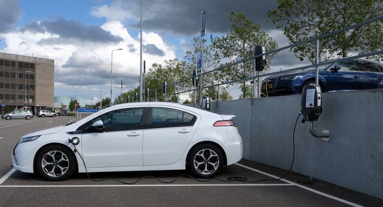 Ein Auto Fahrzeug Elektroauto mit Elektroantrieb vom Typ Opel Ampera E wird an einer Ladestation auf dem Parkplatz im Outletcenter in Roermond mit Strom aufgeladen. ---- A car electric car with electric drive of the type Opel Ampera E is charged with electricity at a charging station on the parking lot in the Outletcenter in Roermond.