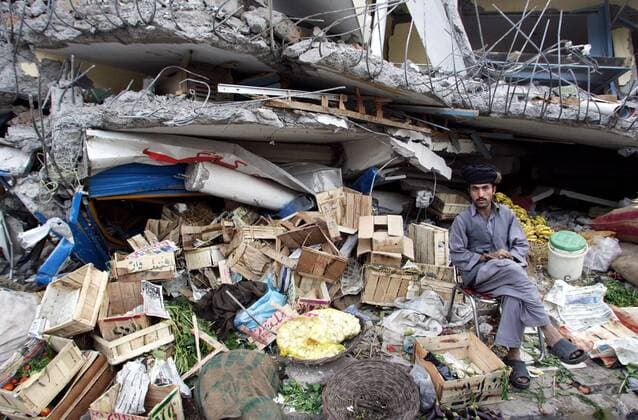 Kaschmir, Pakistan - Erdbeben, zerstoertes Balakot 26.10.2005, Balakot, Kaschmir, Pakistan, PAK - Ein Verkaeufer sitzt neben seinem Gemuese-Verkaufsstand, der sich zum Teil in einer Hausruine befindet. Zerstoerte Stadt Balakot nach dem Erdbeben. Balakot Kaschmir Pakistan *** Kashmir, Pakistan Earthquake, Destroyed Balakot 26 10 2005, Balakot, Kashmir, Pakistan, PAK A seller sits next to his vegetable stall, part of which is in a ruined house Destroyed city of Balakot after the earthquake Balakot Kashmir Pakistan