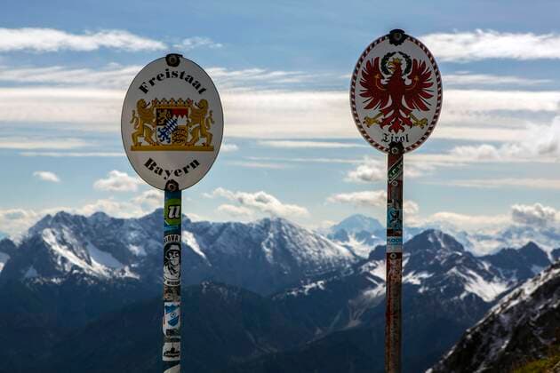Grenzschilder auf der Grenze zwischen Deutschland und Österreich auf einem Grat im Karwendelgebirge in der Nähe der Bergstation der Karwendelbahn. Grenze Deutschland - Österreich