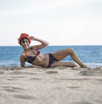 Dunja Rajter Die deutsche Schauspielerin und Sängerin Dunja Rajter im Urlaub posiert im Bikini am Strand mit einer ausgefallenden Badehaube, ca. 1975. The German actress and singer Dunja Rajter on vacation poses in a bikini on the beach with a fancy bathing cap, ca. 1975., Copyright: HelmutxReiss UnitedArchives83000973
