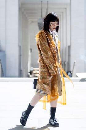 Street Style on day three of London Fashion Week SS 2020 on Saturday September 14th 2019, showcasing stylish individuals London is internationally known for. Image shows stylish Chinese fashion loving fan Freya SinyuSiu. She wears a Burberry trench coat with Burberry rain mac, Balenciaga sunglasses and a long thin tote bag, all with accents of sunflowers  (112123831)