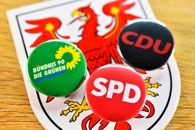 Landeswappen von Brandenburg und Anstecker von SPD, CDU und den GrÃ¼nen, Symbolfoto Kenia-Koalition in Brandenburg