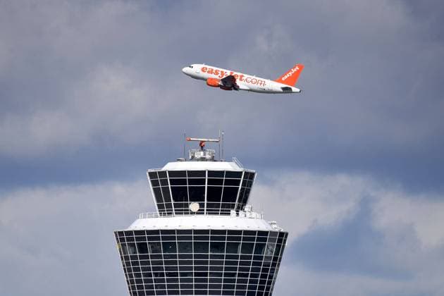 EASY JET ,EASYJET Passagierflugzeug startet hinter dem Tower, Flugverkehr,fliegen.Luftfahrt. Franz Josef Strauss Flughafen in Muenchen.Munich.