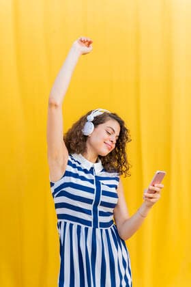 Portrait of young woman with headphones using smartphone model released Symbolfoto  AFVF03676